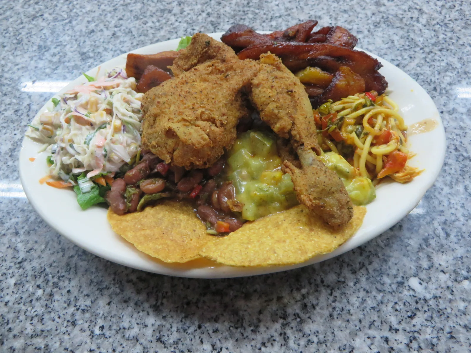 Assiette de casado costaricien avec riz, haricots noirs, plantain et poulet servie dans un soda local