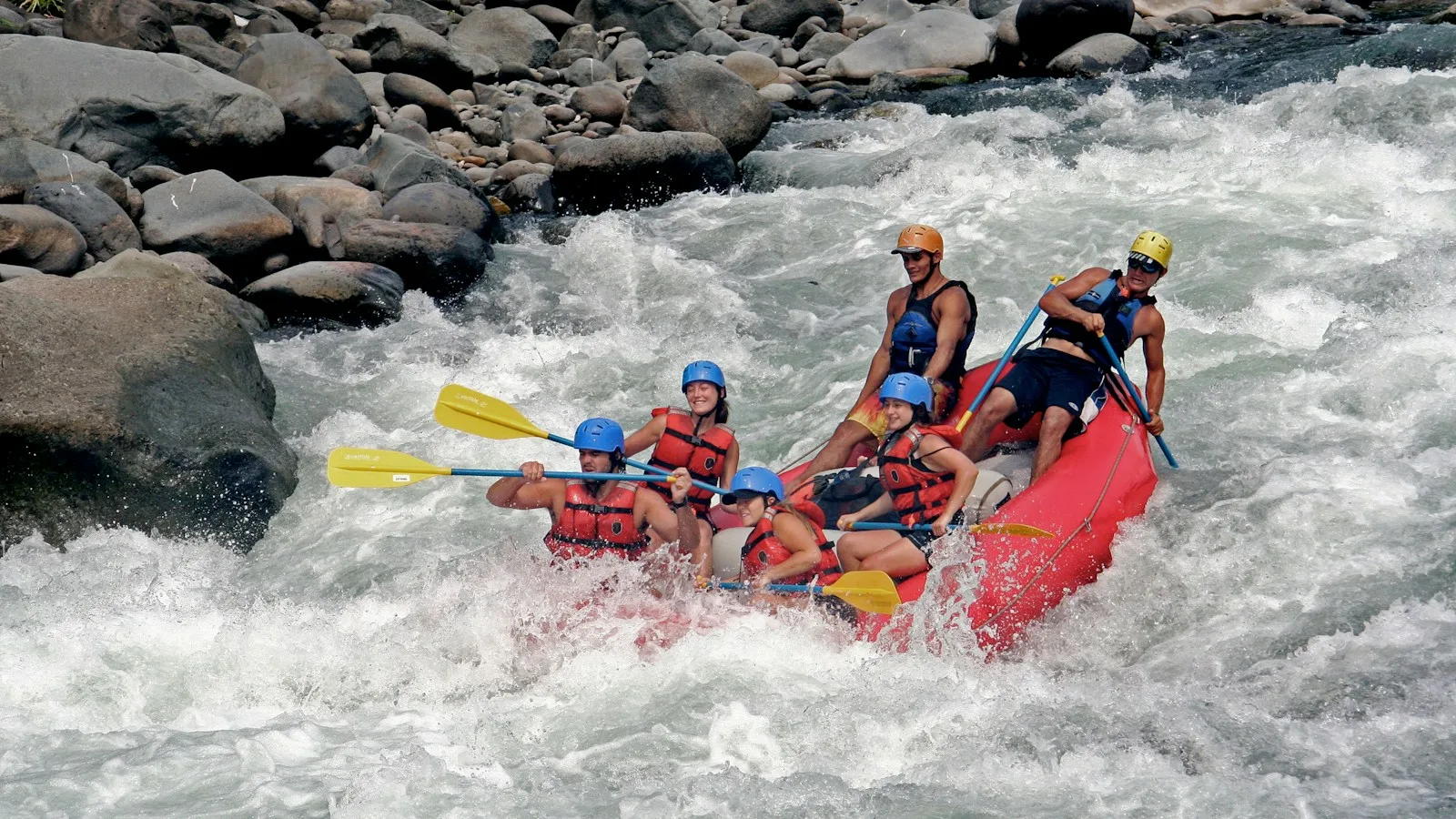 Groupe en rafting dans les rapides d'une rivière bordée de jungle au Costa Rica